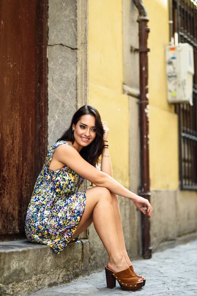 Chica con los ojos azules sonriendo sentado en el paso urbano . — Foto de Stock