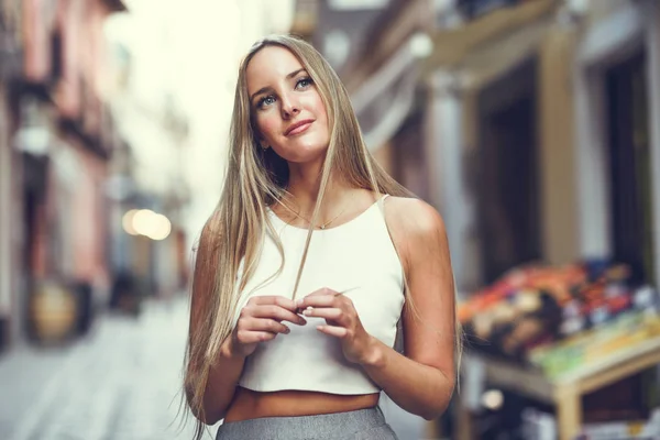Красивая молодая блондинка на городском фоне . — стоковое фото