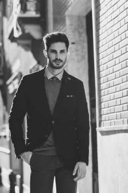 Çekici bir adam sokakta İngiliz şık takım elbise giymiş. Modern saç modeli.