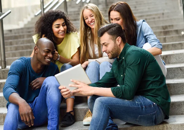 Gruppo multietnico di giovani che guardano un tablet — Foto Stock