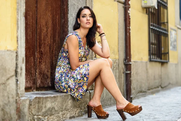Mooie jonge vrouw met blauwe ogen, zittend op stedelijke stap. — Stockfoto