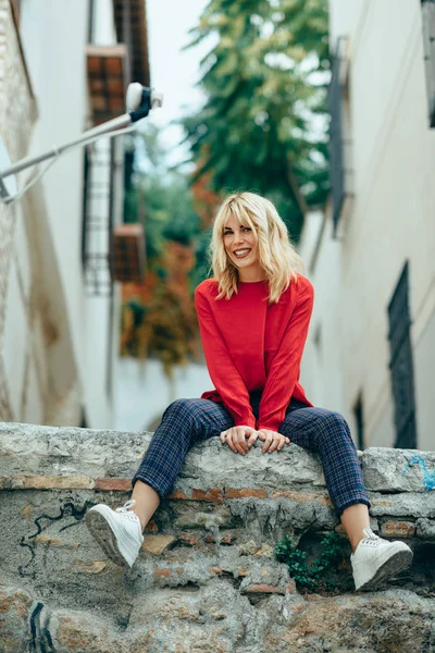 Leende blond flicka med röd tröja njuta av livet utomhus. — Stockfoto