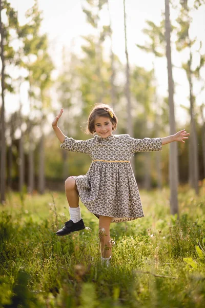 Маленькая девочка в поле природы в красивом платье — стоковое фото