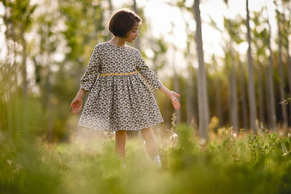 Bambina nel campo della natura indossa un bel vestito — Foto Stock