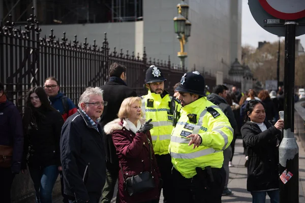 Londyn, Wielka Brytania, 13 kwietnia 2019:-dwóch policjantów pomagających ludziom poza Parlamentem Westminsterskim. — Zdjęcie stockowe