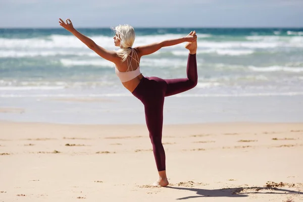 白种人金发碧眼的女人在海滩上练习瑜伽 — 图库照片