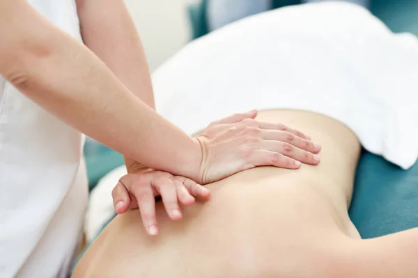 Молода жінка отримує масаж спини професійним терапевтом . — стокове фото