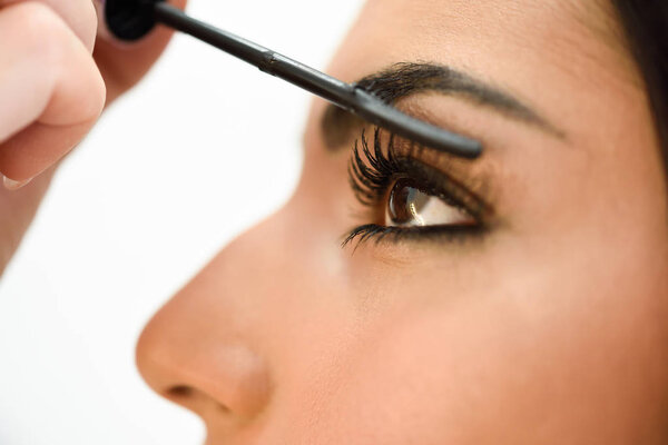 Make-up artist putting on the eyelashes of an African woman