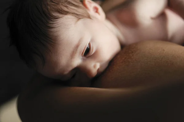Jovem mãe amamentando bebê recém-nascido em casa — Fotografia de Stock