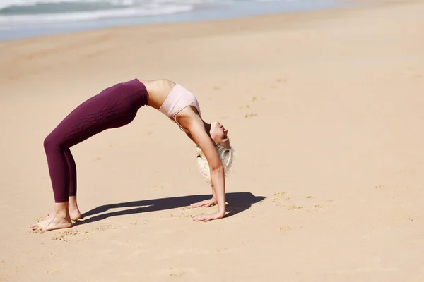 Mulher loira caucasiana praticando ioga na praia — Fotografia de Stock