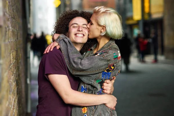 Young couple hugging in urban background on a typical London street. — Stock Photo, Image