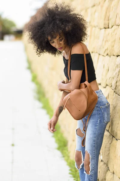 Mladá žena smíšené s afro vlasy stojící na ulici — Stock fotografie