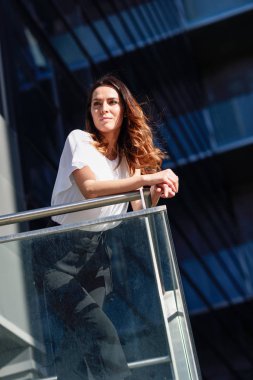 Bir ofis binasının dışında duran emin iş kadını.