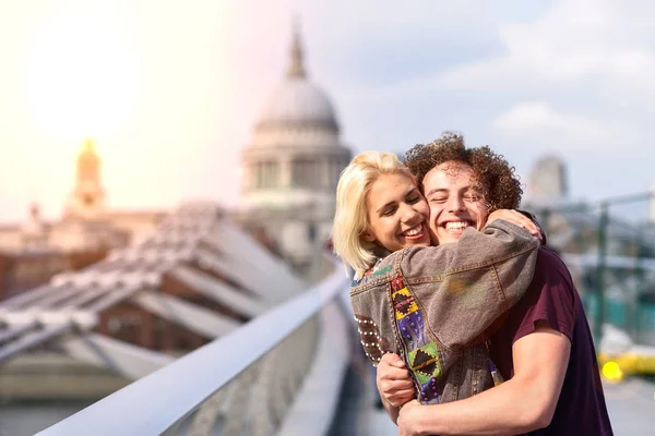 Szczęśliwa para przytulanie przez Millennium Bridge, Tamiza, Londyn. — Zdjęcie stockowe