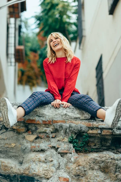 Sorrindo menina loira com camisa vermelha apreciando a vida ao ar livre . — Fotografia de Stock
