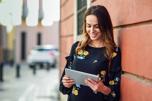 Mujer joven sonriente usando tableta digital al aire libre . —  Fotos de Stock