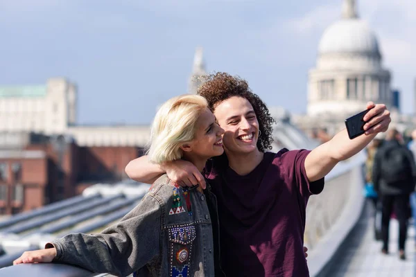 Szczęśliwa para biorąc zdjęcie selfie na Londons Millennium Bridge — Zdjęcie stockowe
