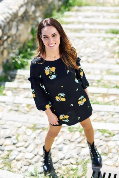 Middle-aged woman wearing flowered dress in urban steps. — Stock Photo, Image