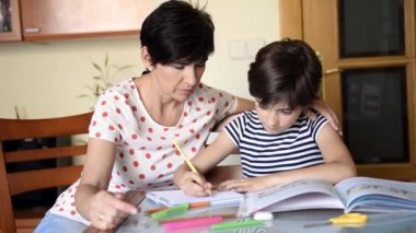 Orta yaşlı anne ona ödev ile kızı yardımcı olur.