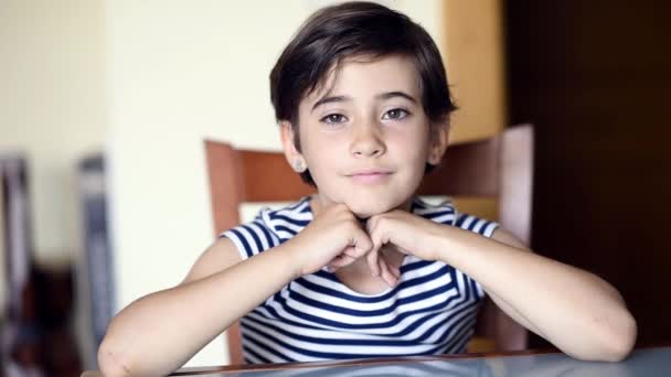 Funny eight-year-old girl putting different expressions to the camera indoors. — Stock Video