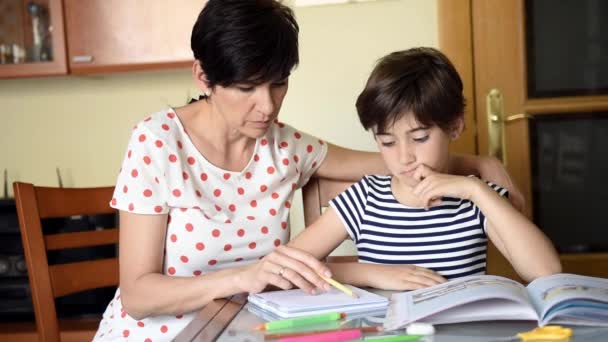 Medelålders mamma hjälper sin dotter med sina läxor. — Stockvideo