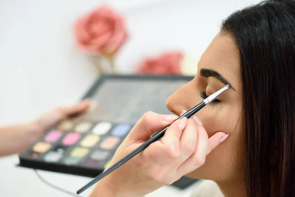 Make-up artiest maken-up op een dames wenkbrauwen — Stockfoto