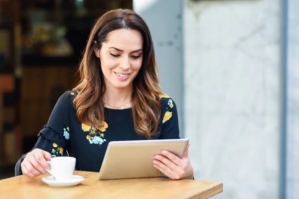 Mujer de mediana edad que utiliza la tableta en la pausa para el café en la cafetería urbana . —  Fotos de Stock