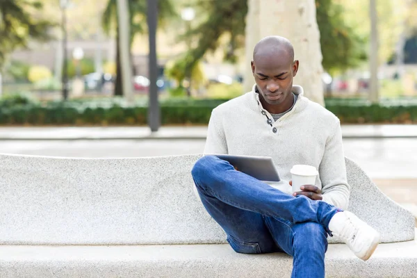 Schwarzer junger Mann mit Tablet-Computer und Kaffee zum Mitnehmen — Stockfoto