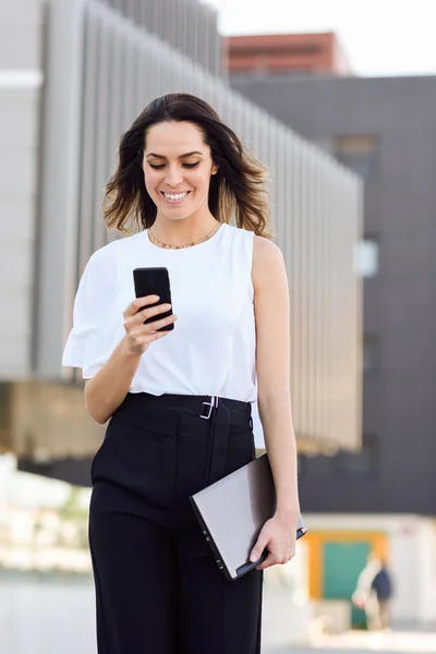 Mujer de negocios trabajando con su teléfono inteligente y portátil al aire libre . — Foto de Stock