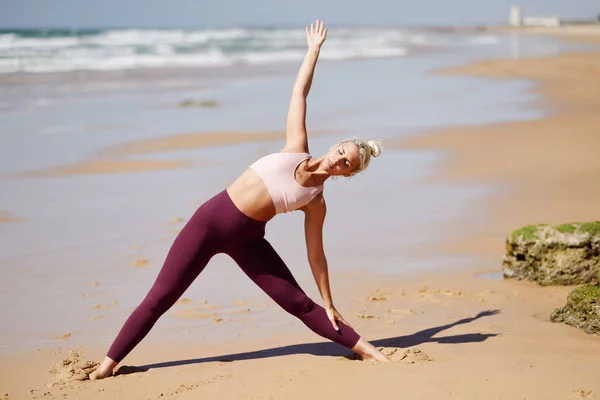 Caucasian blonde woman practicing yoga in the beach — Stock Photo, Image