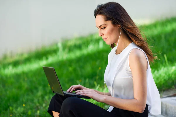 Jovem mulher trabalhando com seu computador portátil sentado no chão . — Fotografia de Stock