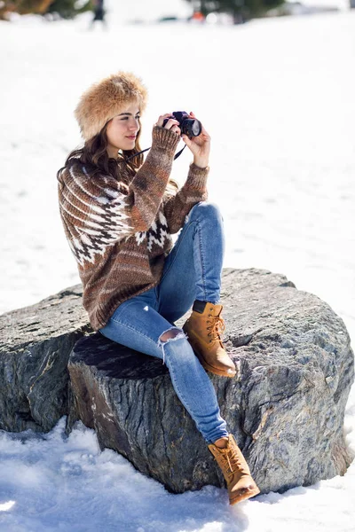 Mladá žena fotografuje ve zasněžených horách — Stock fotografie