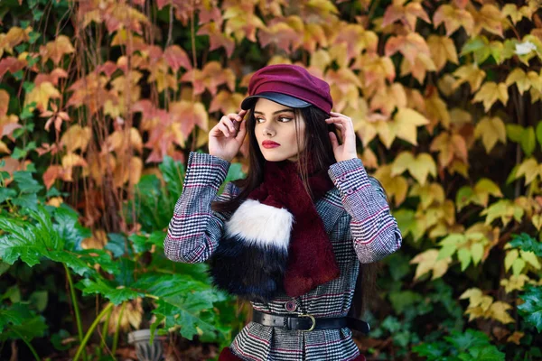 Menina bonita nova com cabelos muito longos usando casaco de inverno e boné no outono folhas fundo — Fotografia de Stock