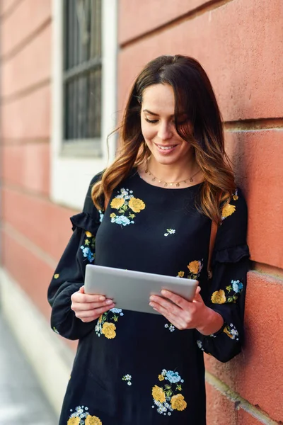 Mujer joven sonriente usando tableta digital al aire libre . —  Fotos de Stock