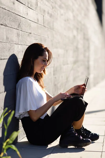 Joven mujer de negocios trabajando con su computadora portátil sentada en el suelo . —  Fotos de Stock