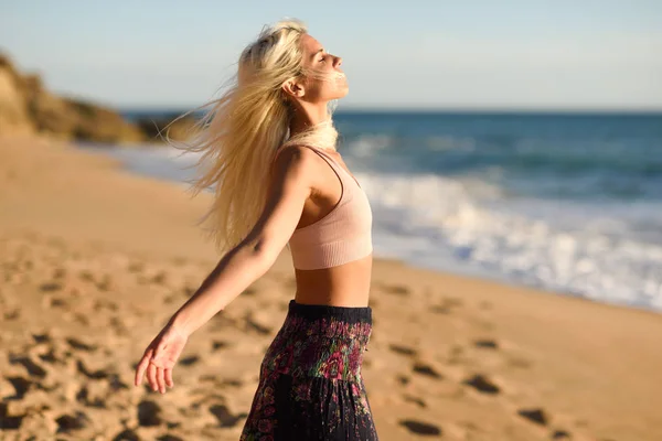 Mujer disfrutando de la puesta de sol en una hermosa playa — Foto de Stock