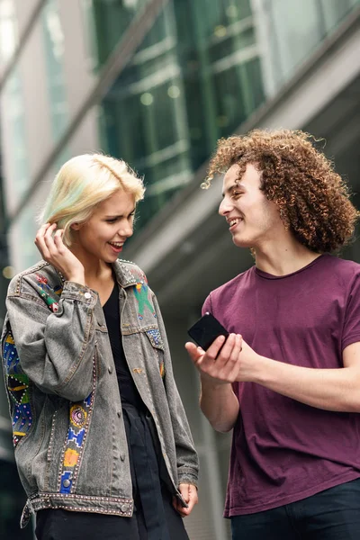 Pareja feliz usando teléfono inteligente en el fondo urbano . —  Fotos de Stock