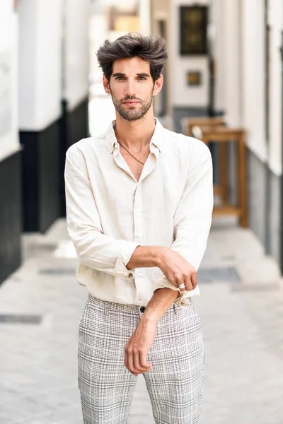 Jovem atraente com cabelo escuro e penteado moderno vestindo roupas casuais ao ar livre — Fotografia de Stock