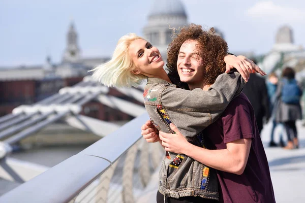 Glückliches Paar, das sich an Millennium Bridge, Themse, London umarmt. — Stockfoto