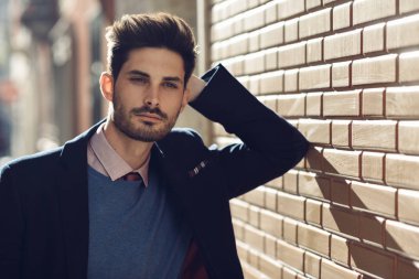 Çekici bir adam sokakta İngiliz şık takım elbise giymiş. Modern saç modeli.