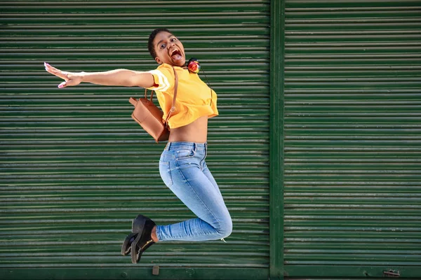Junge schwarze Frau springt auf Jalousien Hintergrund. — Stockfoto