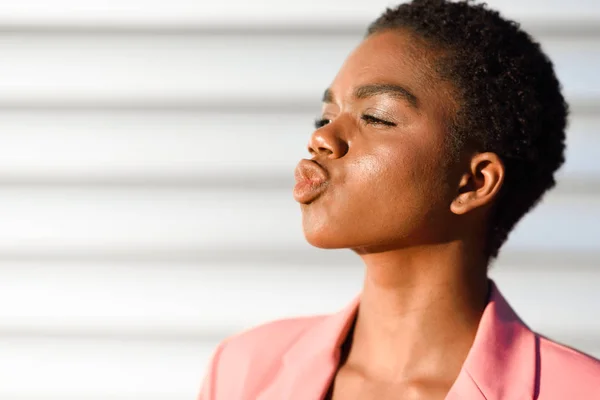 黒人女性、非常に短い髪でキスを吹く. — ストック写真