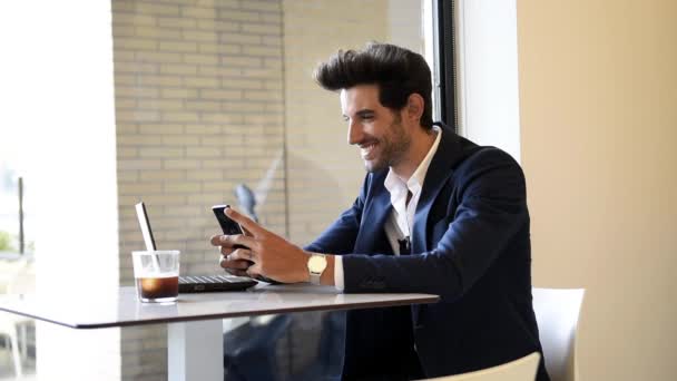 Uomo d'affari seduto nel caffè, bere caffè fresco con lo smartphone . — Video Stock