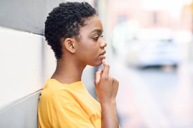 Thoughtful black woman with sad expression outdoors. clipart