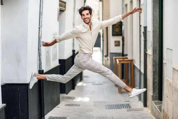 Junger glücklicher Mann springt auf die Straße. — Stockfoto