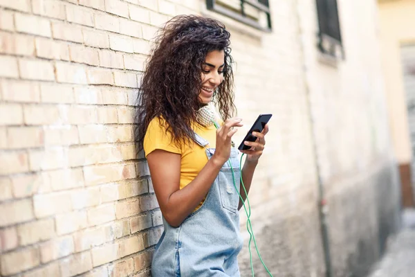 Genç Kuzey Afrikalı kadın akıllı telefon açık havada manifatura — Stok fotoğraf