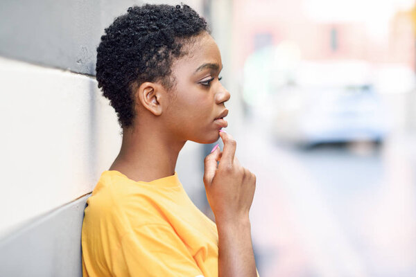 Thoughtful black woman with sad expression outdoors.