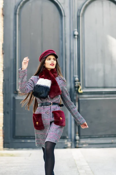 Menina bonita feliz com cabelos muito longos usando casaco de inverno e boné ao ar livre . — Fotografia de Stock