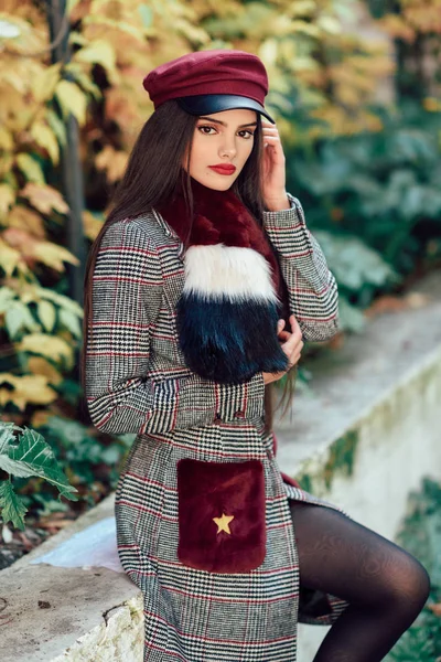Fiatal gyönyörű lány nagyon hosszú haj visel téli kabát és sapka őszi levelek háttér — Stock Fotó