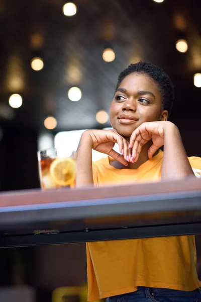 Jonge zwarte vrouw met zeer kort haar nemen van een glas koude thee. — Stockfoto